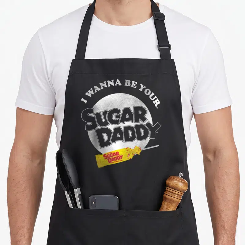 Tablier de cuisine noir avec inscription I Wanna Be Your Sugar Daddy et une image de candy jaune.