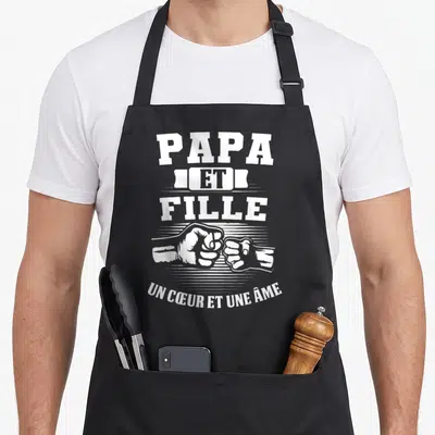 Tablier de cuisine noir avec inscription Papa Et Fille et deux poings qui se touchent en blanc.