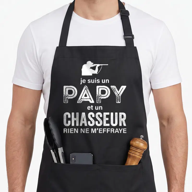 Tablier de cuisine noir avec une silhouette blanche d'un chasseur et le texte je suis un papy et un chasseur rien ne m'effraye.