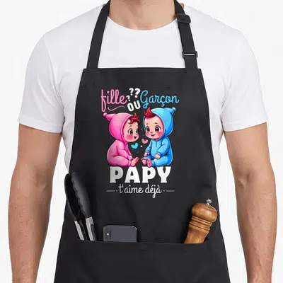 Tablier de cuisine noir avec illustration de deux bébés rose et bleu et le texte Papy t'aime déjà.