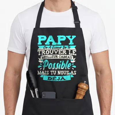 Tablier de cuisine noir avec inscription Papy On A Essayé De Te Trouver Le Meilleur Cadeau Possible en lettres turquoise et blanches.