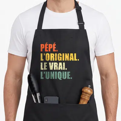 Tablier de cuisine noir avec les mots Pépé l'original le vrai l'unique en couleurs vives.