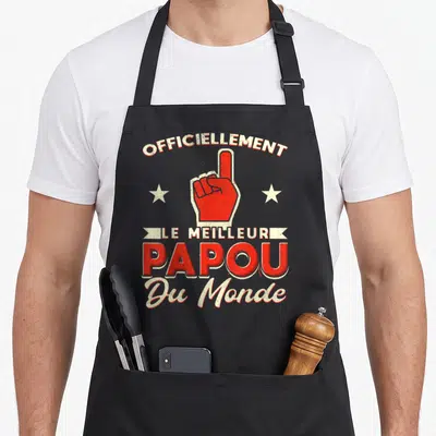 Tablier de cuisine noir avec une main rouge pointant vers le haut et le texte « officiellement le meilleur papou du monde » imprimé en blanc et rouge.