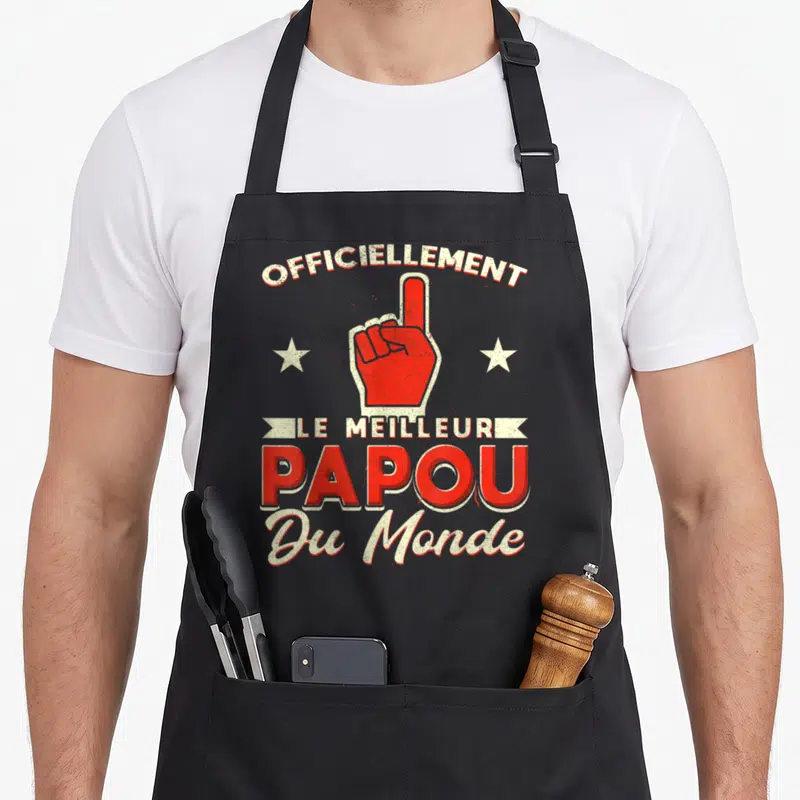 Tablier de cuisine noir avec une main rouge pointant vers le haut et le texte « officiellement le meilleur papou du monde » imprimé en blanc et rouge.