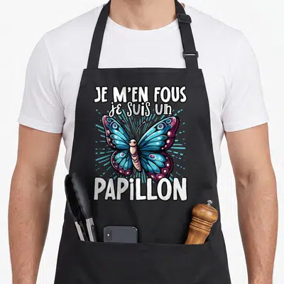 Tablier de cuisine noir avec un papillon bleu et violet et le texte Je m'en fous je suis un papillon en blanc.