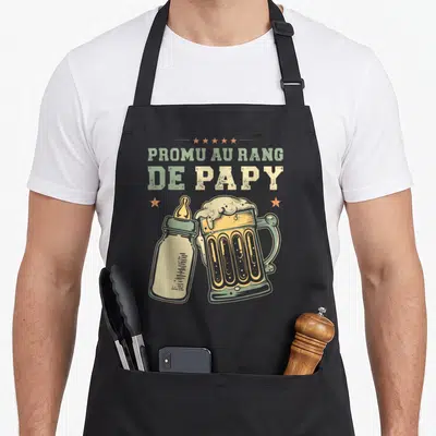 Tablier de cuisine noir avec illustration vintage d'un biberon et d'une chope de bière sous le texte Promu au rang de Papy.