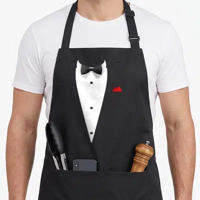 Tablier de cuisine noir avec motif costume de soirée blanc, noeud papillon noir et mouchoir rouge.