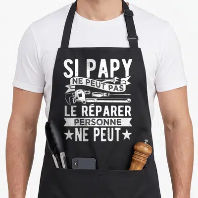 Tablier de cuisine noir avec inscription blanche « Si papy ne peut pas le réparer personne ne peut » et illustrations d'outils.