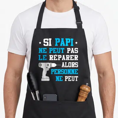 Tablier de cuisine noir avec inscription blanche et bleue Si Papi ne peut pas le réparer et une perceuse électrique blanche.