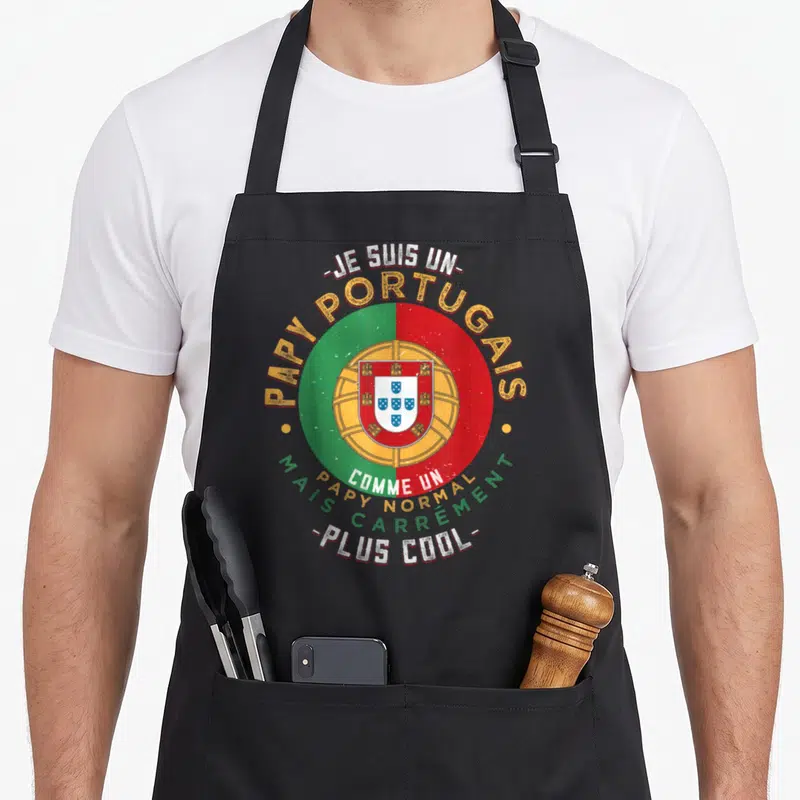 Tablier de cuisine noir avec un logo circulaire aux couleurs du drapeau portugais et des textes humoristiques en jaune et blanc.