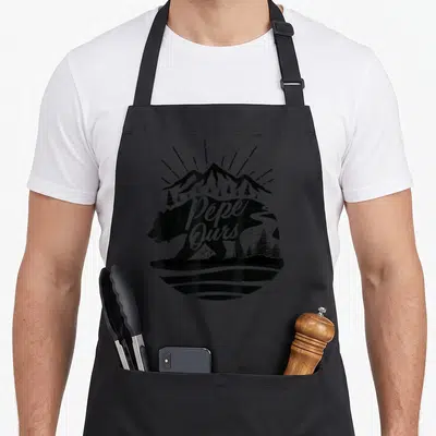 Tablier de cuisine noir avec silhouette d'ours, montagnes et inscription Pépe Ours en blanc.