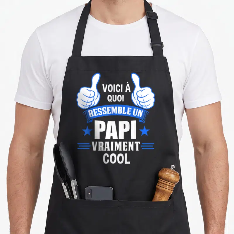 Tablier de cuisine noir avec deux mains blanches faisant des pouces levés et le texte voici à quoi ressemble un papi vraiment cool en blanc et bleu.