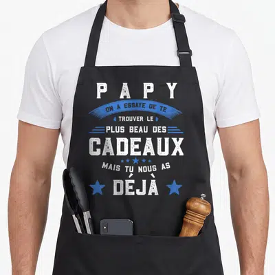 Tablier de cuisine noir avec une inscription blanche et bleue rendant hommage au rôle du grand-père dans la famille.