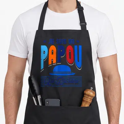 Tablier de cuisine noir avec l'inscription Je suis un papou qui déchire et une illustration de casquette bleue vintage.