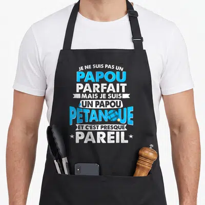 Tablier de cuisine noir avec inscription humoristique sur la pétanque et le rôle de grand-père en lettres bleues et blanches.