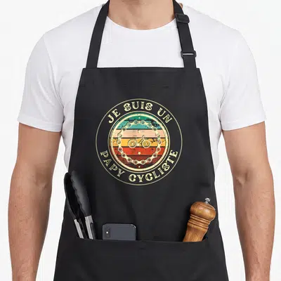 Tablier de cuisine noir avec motif circulaire vintage représentant une chaîne de vélo et des bandes colorées.