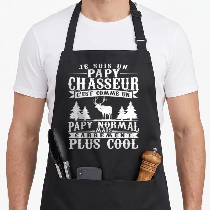 Tablier de cuisine noir avec inscription blanche Je suis un papy chasseur illustré d'un cerf et d'arbres.