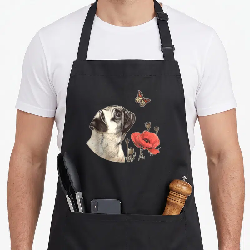 Tablier de cuisine noir avec illustration d'un carlin regardant un papillon près de fleurs rouges.