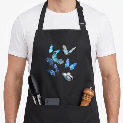 Tablier de cuisine noir avec plusieurs papillons morpho aux ailes bleues lumineuses et détaillées en vol.