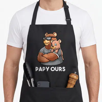 Tablier de cuisine noir avec illustration d'un ours papa aux lunettes noires tenant un ourson et le texte Papy Ours en blanc.