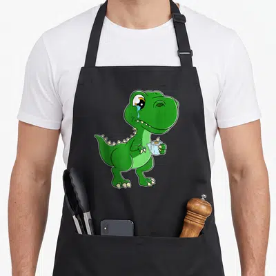 Tablier de cuisine noir avec un dinosaure vert pleurant tenant une rouleau de papier toilette.