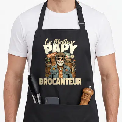 Tablier de cuisine noir avec illustration d'un papy brocanteur souriant entouré d'objets vintage et du texte Le Meilleur Papy Brocanteur.