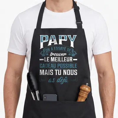 Tablier de cuisine noir avec typographie blanche et bleue affichant un message affectueux pour un grand-père.