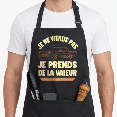 Tablier de cuisine noir avec inscription jaune et illustration de voiture vintage orange sur le devant.