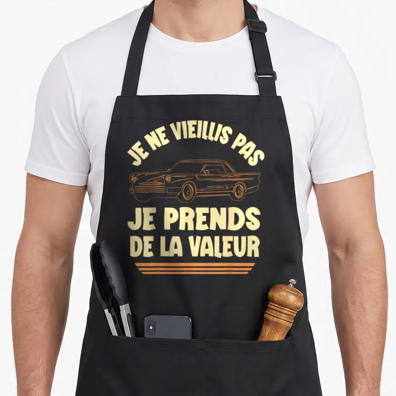 Tablier de cuisine noir avec inscription jaune et illustration de voiture vintage orange sur le devant.