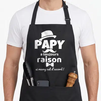 Tablier de cuisine noir avec l'inscription Papy a toujours raison si mamy est d'accord orné d'un chapeau et d'une moustache blanche.