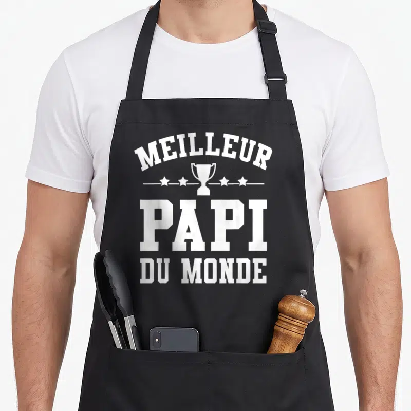 Tablier de cuisine noir avec inscription Meilleur Papi du Monde et illustration de trophée blanc au centre.
