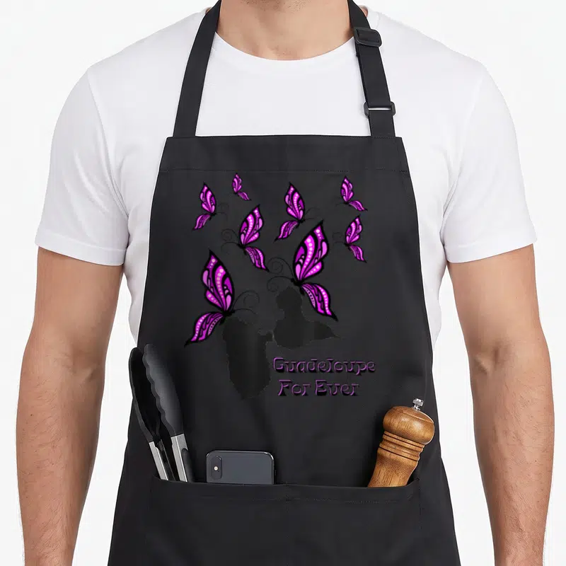 Tablier de cuisine noir avec silhouette de Guadeloupe, papillons violet et texte For Ever imprimé en bas à droite.