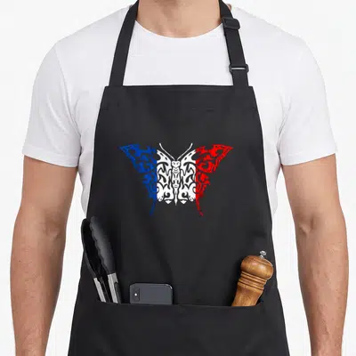 Tablier de cuisine noir avec un papillon aux ailes bleue blanche et rouge inspiré du drapeau français et de motifs tribaux.