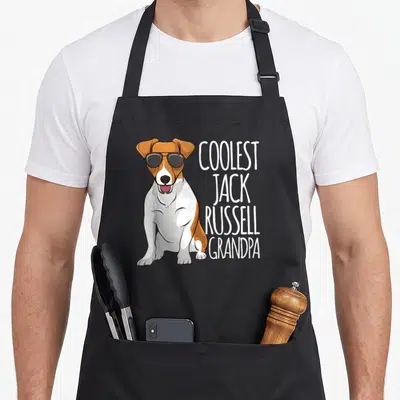Tablier de cuisine noir avec un Jack Russell en lunettes noires et le texte Coolest Jack Russell Grandpa imprimé en blanc.