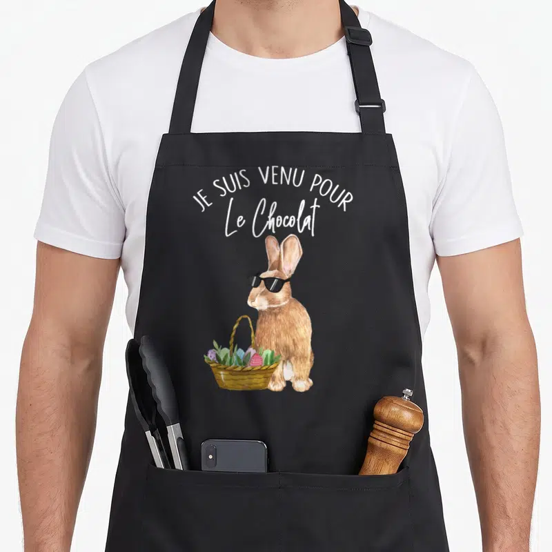 Tablier de cuisine noir avec un lièvre portant des lunettes noires et tenant un panier d'œufs de Pâques sous la mention Je suis venu pour le Chocolat.