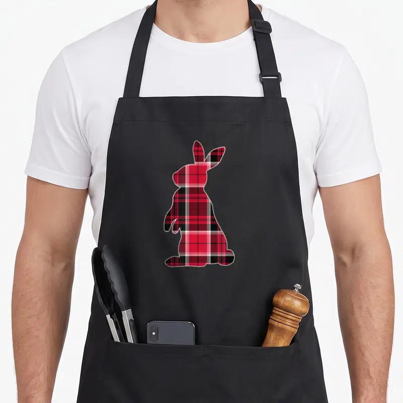 Tablier de cuisine noir avec silhouette de lapin remplie d'un motif de plaid rouge et noir.