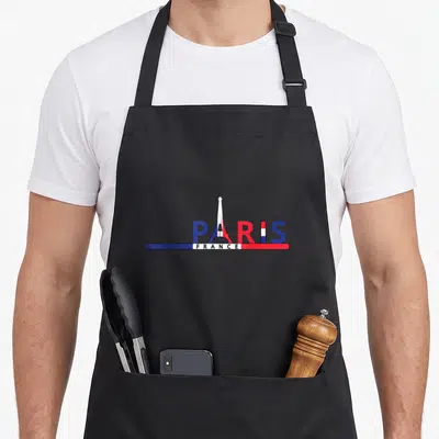 Tablier de cuisine noir avec le mot Paris stylisé par la Tour Eiffel et une bannière tricolore France en dessous.