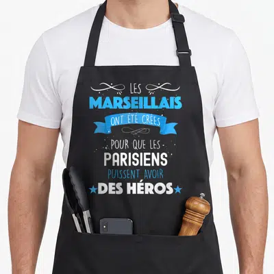 Tablier de cuisine noir avec inscription Les Marseillais ont été créés pour que les Parisiens puissent avoir des héros en bleu et blanc.