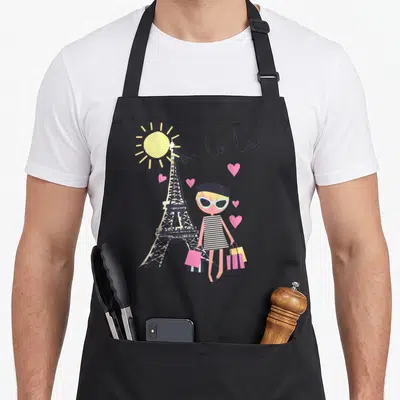 Tablier de cuisine noir avec illustration d'une femme en beret devant la Tour Eiffel et le texte oo la la.