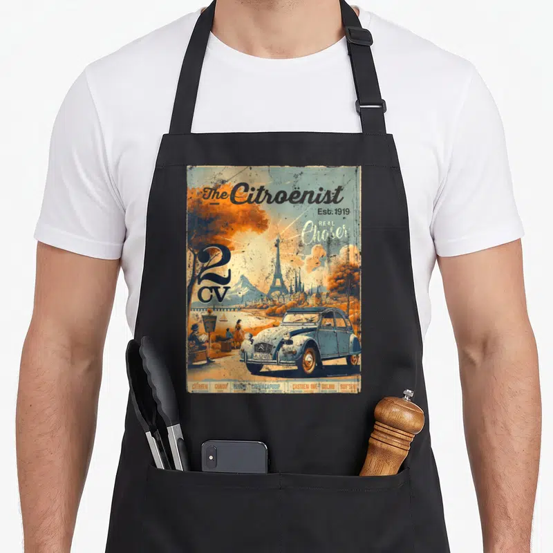 Tablier de cuisine noir avec illustration vintage d'une 2CV bleue devant la Tour Eiffel et le texte The Citroenist.