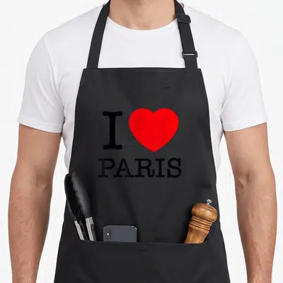 Tablier de cuisine noir avec l'inscription I Love Paris et un grand cœur rouge au centre du design.