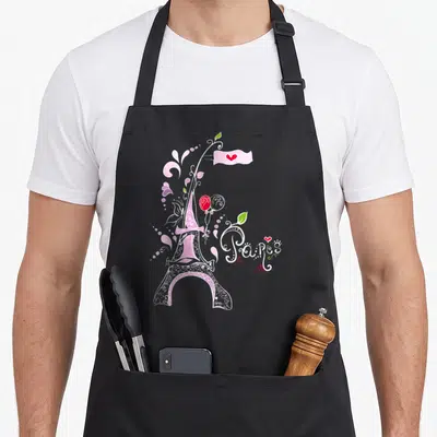 Tablier de cuisine noir avec une illustration rose de la Tour Eiffel, un ballon rouge et le mot Paris en lettres blanches.