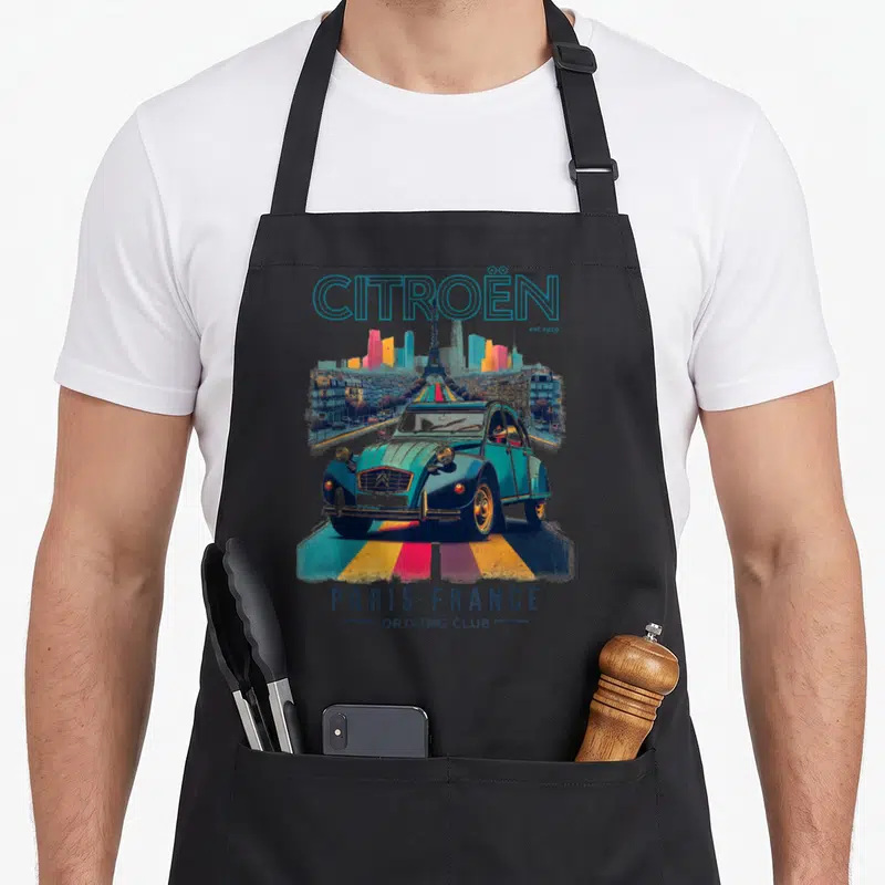 Tablier de cuisine noir avec illustration d'une Citroën 2CV turquoise sur les Champs-Élysées face à la Tour Eiffel et des bâtiments colorés.