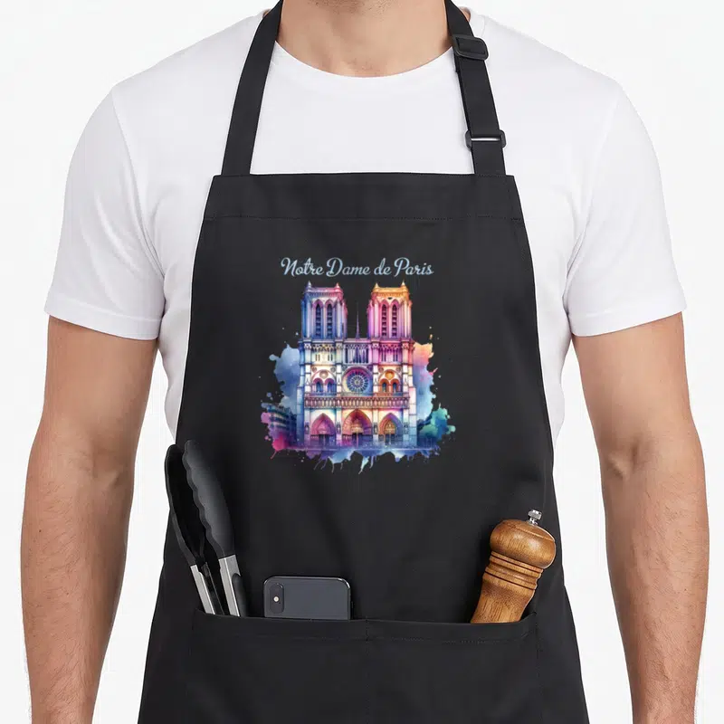 Tablier de cuisine noir avec une aquarelle colorée représentant la façade de Notre Dame de Paris et son roseau central.