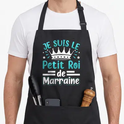 Tablier de cuisine noir avec l'inscription Je suis le Petit Roi de Marraine et une illustration de couronne blanche entourée d'étoiles.