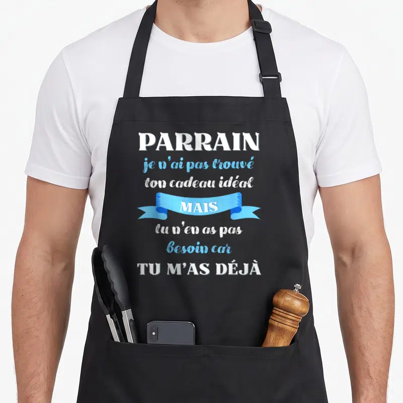Tablier de cuisine noir avec inscription blanche et bleue « Parrain tu m'as déjà » sur fond uni.