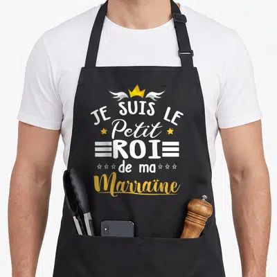 Tablier de cuisine noir avec inscription Je Suis Le Petit Roi De Ma Marraine et couronne à ailes dorée.
