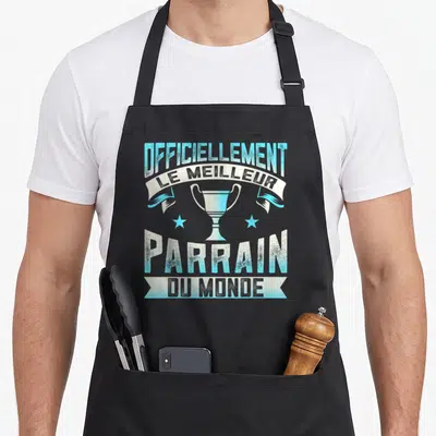 Tablier de cuisine noir avec un trophée bleu et le texte « Officiellement le meilleur parrain du monde » imprimé en typographie vintage.