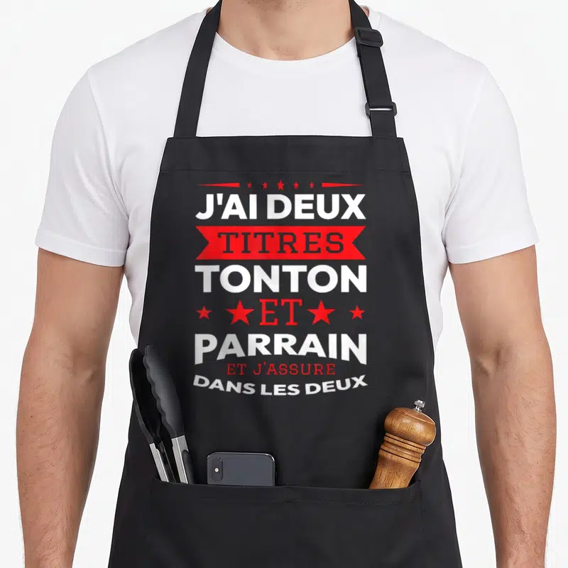 Tablier de cuisine noir avec inscription blanche et rouge J'ai deux titres tonton et parrain et j'assure dans les deux.