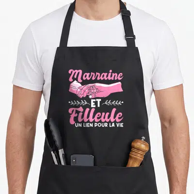 Tablier de cuisine noir avec inscription Marraine et Filleule Un lien pour la vie et illustration de deux mains jointes en rose.